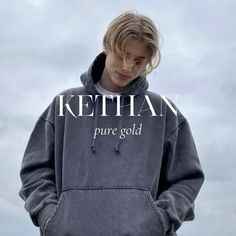 a young man wearing a grey sweatshirt with the words ketchan pure gold on it