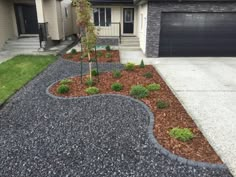 a driveway with gravel and landscaping in front of it