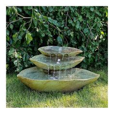 three bowls are stacked on top of each other with water running down them in the grass