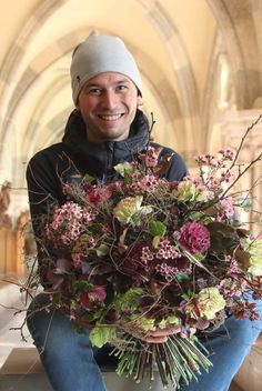 a man holding a large bouquet of flowers