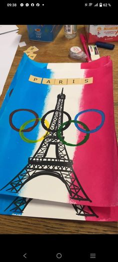 a piece of paper with the eiffel tower painted on it, sitting on a table