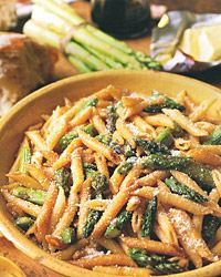 pasta with asparagus and parmesan cheese in a wooden bowl on a table