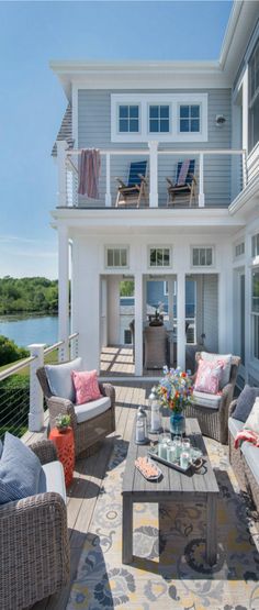 an image of a house with furniture on the porch and in the background is a lake