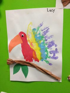 a paper plate with a colorful bird on it next to some crayon markers