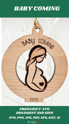 a wooden ornament with the words baby coming in black and white on it