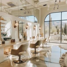 a salon with chairs and mirrors in front of large windows that overlook the desert outside