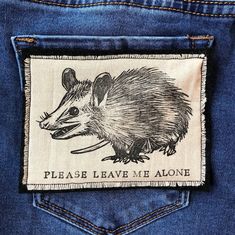 a patch on the back of a pair of jeans with an image of a rat