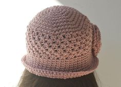 a crocheted pink hat is shown on top of a woman's head