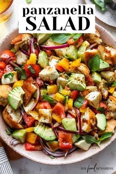 a salad with chicken, tomatoes, cucumbers and onions in a white bowl