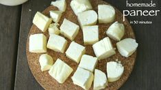 homemade paneer is cut up on a cutting board and ready to be served with milk