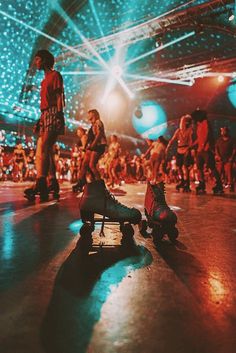 skateboarders are in the middle of a large room with blue lights on it