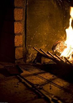 a fire burning inside of a brick oven