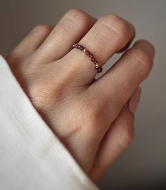 Elastic ring made of gemstones - garnet with tiny silver or  gold-plated balls made of sterling silver 925. Stone size: approx. 2 mm The energy of the garnet allows you to overcome the fear of the unknown, so it is perfect for people who are afraid to make any changes in their own lives. It is a stone of new hope and at the same time a symbol of flourishing in times of failure or despondency. It helps you find the energy to tread hard on the ground towards achieving your goals. In alternative medicine, garnet helps in the treatment of circulatory disorders, allergies and asthma. 3 available sizes: S - 48-51mm M - 52-55mm L - 56-59 mm It is possible to make any size on request. Elastic Rings, Fear Of The Unknown, Stretch Ring, New Hope, The Fear, Garnet Rings, The Unknown, Nature Bracelets, Multi Stone Ring