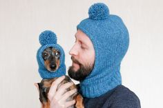 a man wearing a blue hat holding a small dog