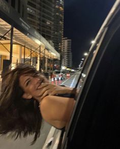 a woman leaning out the window of a car