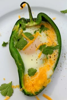 an egg in a green pepper on a white plate