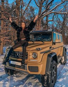 a woman sitting on top of a mercedes benz