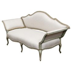 an old fashioned couch with white upholstered fabric