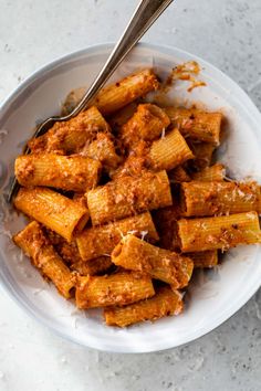 a white bowl filled with pasta covered in sauce