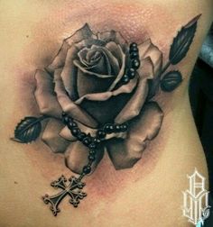 a woman's stomach with a rose and cross on it