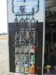 the inside of a horse trailer with several horses in it's stalls and various items hanging from hooks