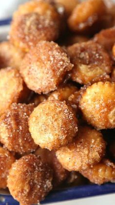 some sugared donuts are in a blue and white bowl