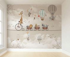 a wall mural with animals on a bike and hot air balloons flying in the sky