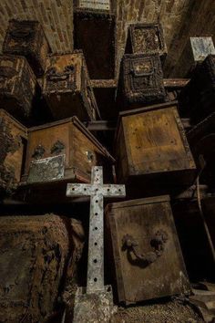 an old wooden cross is surrounded by boxes