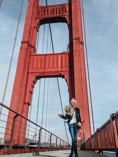 a woman standing in front of the golden gate bridge