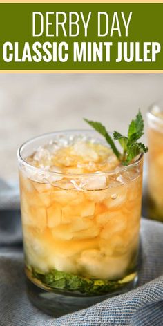 two glasses filled with ice and mint on top of a blue cloth next to a napkin