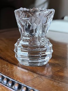 a glass vase sitting on top of a wooden table