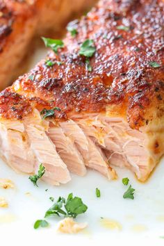 two pieces of meat on a plate with parsley sprinkled around the edges