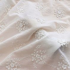 an image of white fabric with flowers on it