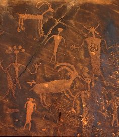 rock paintings depicting people and animals on the side of a cliff