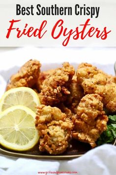 fried oysters on a plate with lemon wedges and parsley in the background