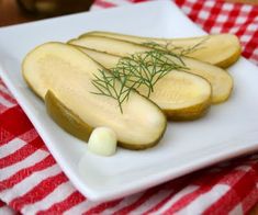 sliced cucumbers on a white plate with green sprigs