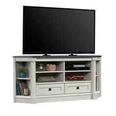 a flat screen tv sitting on top of a white entertainment center with drawers underneath it