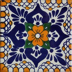 a blue and white tile with an orange flower in the center, on top of it