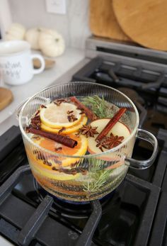 a glass bowl filled with apples and cinnamons on top of a stove burner