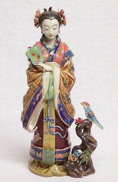 a figurine of a woman with a bird on her arm