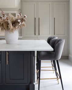 a vase with flowers sitting on top of a kitchen island