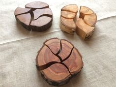 three pieces of wood sitting on top of a white table cloth next to each other