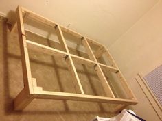 a wooden shelf sitting on top of a carpeted floor