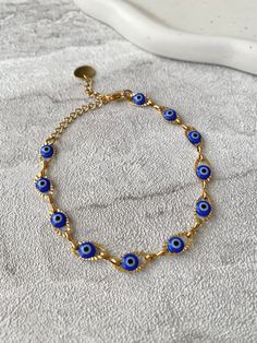 🧿 Stunning handmade Blue Evil eye jewellery, crafted from tarnish resistant stainless steel 🧿 The evil eye is a protective and powerful symbol, also known as the Nazar. The evil eye helps to absorb negative energies, protect and bring luck. The evil eye makes a perfect gift for yourself and loved ones.  Hand of Fatima Necklace https://www.etsy.com/uk/listing/1556603231/hamsa-hand-of-fatima-gold-pendant?click_key=a6f5da90d8d8ea8bd774c20becf761f1cd89bc53%3A1556603231&click_sum=a9a084e9&ref=shop_home_active_3 Hand of Fatima Earrings https://www.etsy.com/uk/listing/1542499652/hamsa-hand-of-fatima-gold-stud-earrings?click_key=89cabcb8ef68040716616f6d3e33732975d65ab1%3A1542499652&click_sum=5e820e7d&ref=shop_home_active_1 💎Jewellery Care💎 To ensure the longevity of your jewellery please avoid Nazar Eye Necklace, Metal Evil Eye Bracelet As Gift, Metal Evil Eye Bracelet Gift, Gift Metal Evil Eye Round Bracelet, Handmade Metal Evil Eye Bracelet, Handmade Metal Evil Eye Bracelet For Gift, Metal Evil Eye Bracelet, Metal Evil Eye Bracelet With Adjustable Chain As Gift, Metal Evil Eye Jewelry