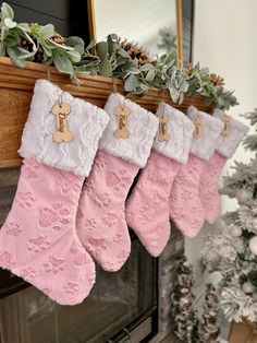 three stockings hanging from a mantel decorated for christmas