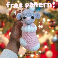 a hand holding a small stuffed animal in front of a christmas tree with the words free pattern