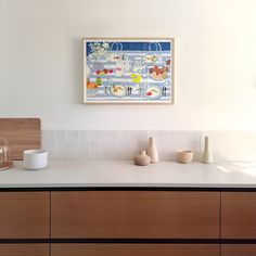 a kitchen counter with vases on it and a painting hanging above the counter top