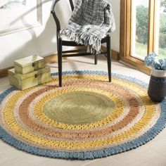 a chair sitting in front of a window next to a rug