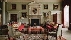 a living room filled with furniture and paintings on the wall above it's fireplace