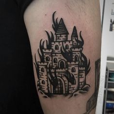 a black and white tattoo of a castle with flames on it's side arm